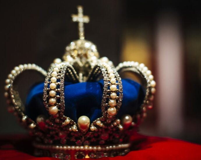 navy and gold crown on red velvet cushion. The Crown.