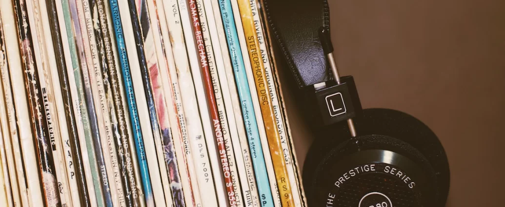 records resting on a shelf next to a pair of headphones