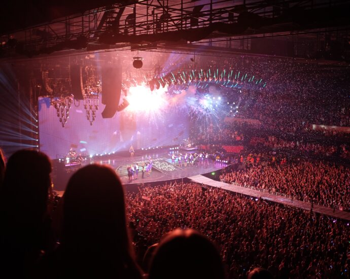 A photo from Taylor Swift's 1989 world tour. The stage lights are orange, blue and purple. Fans will be excited to see if she includes her track All Of The Girls You Loved Before on the setlist for her ongoing Eras tour.