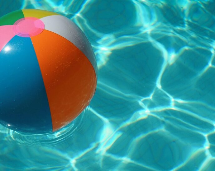 Beach ball in a clear blue swimming pool