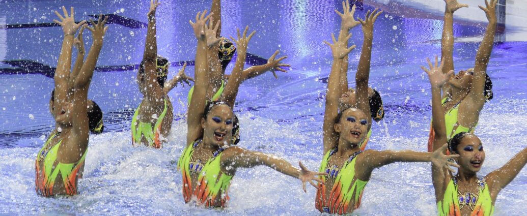 a team of young women completing an artistic swimming performance
