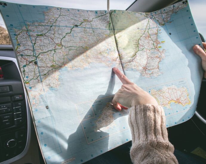 A person pointing at a map with their index finger. Empoword's travel tips and tricks.