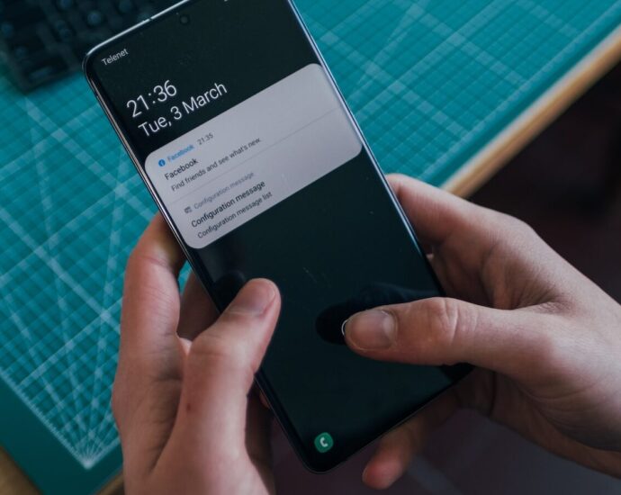 A person holding a phone with two app notifications
