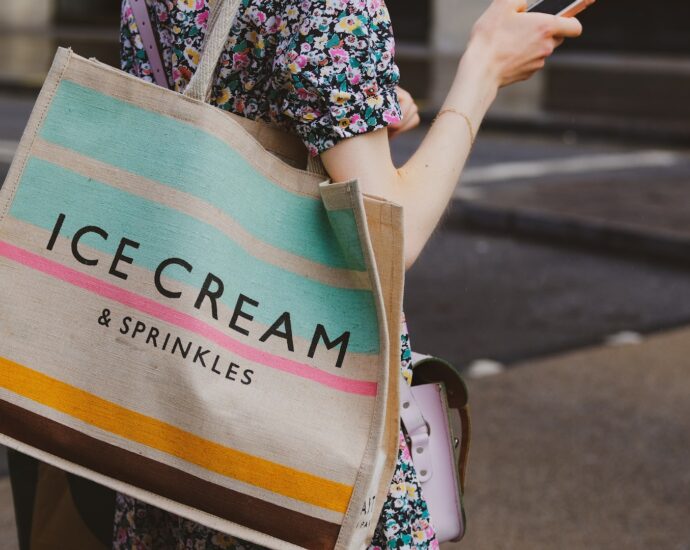 a person carrying a multi-coloured tote bag