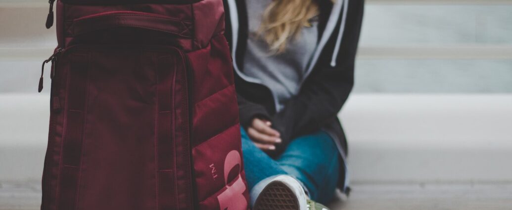 a woman sitting on the floor with her suitcase, about to embark on her Euro Summer trip.