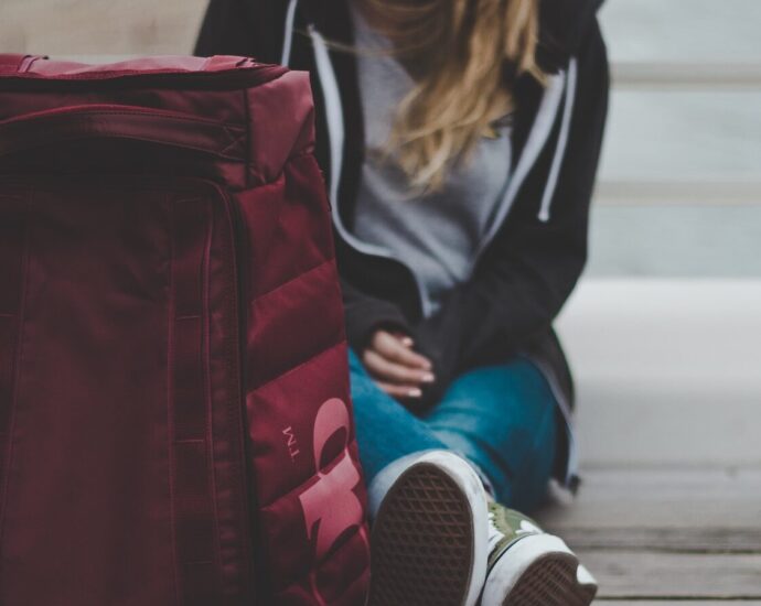 a woman sitting on the floor with her suitcase, about to embark on her Euro Summer trip.