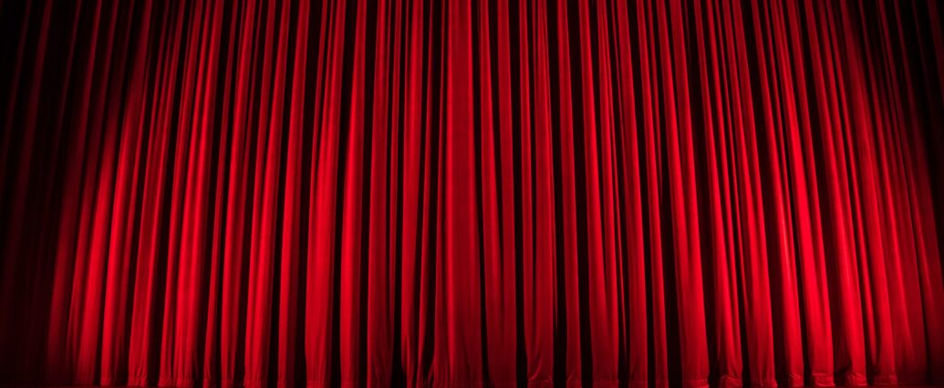 Theatre stage with red curtain drawn,