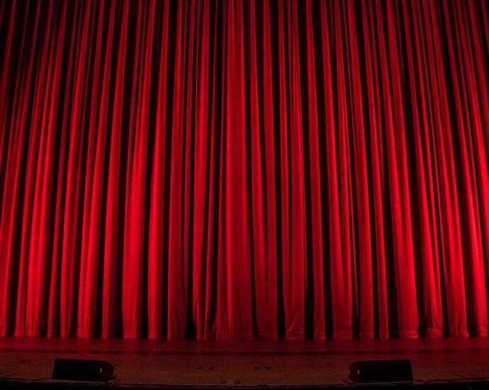 Theatre stage with red curtain drawn,