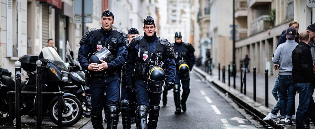 Armed police officers walk down an alley in France