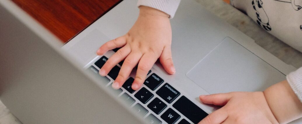Child using a laptop to represent the way working mothers face disproportionate inequality in the workplace.