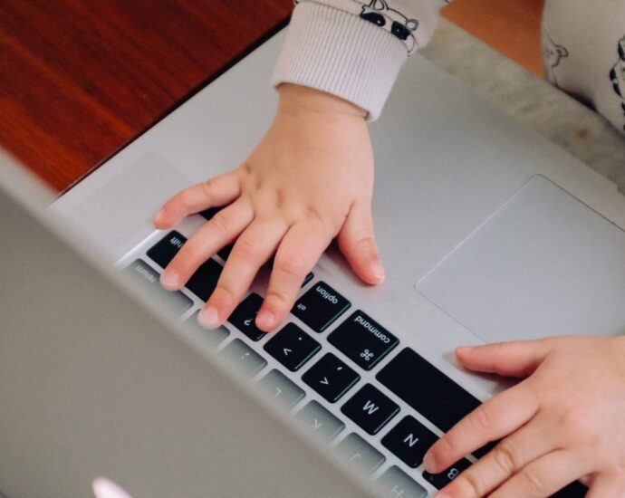 Child using a laptop to represent the way working mothers face disproportionate inequality in the workplace.