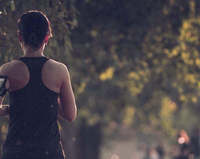 A woman running through a wooded area.