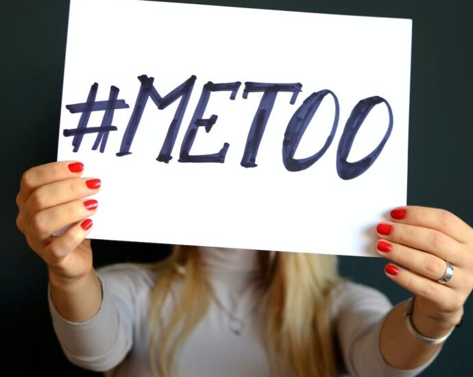 Woman holding paper that says "me too".
