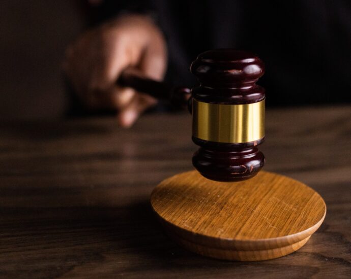 A wooden gavel is struck against a sound block.
