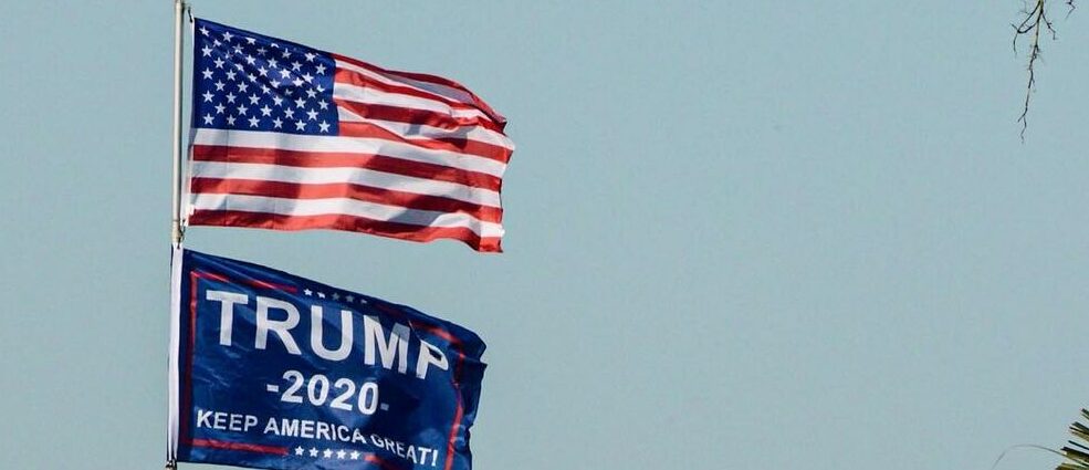 An image of a USA flag, and a Trump 2020 presidential flag.
