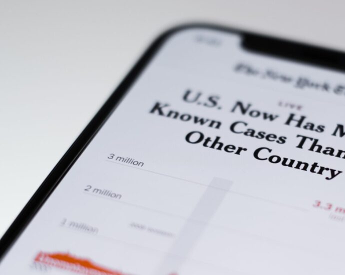 Image shows a phone with a news article shown on-screen [ingore: media and health anxiety]