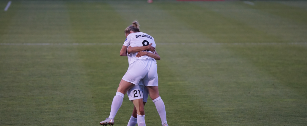 two England lionesses celebrating on the pitch