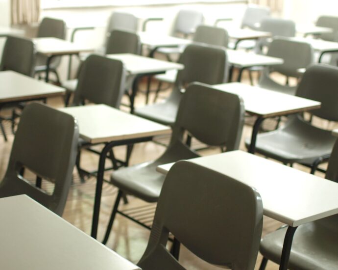 Image of chairs and desks lined up in a school hall.