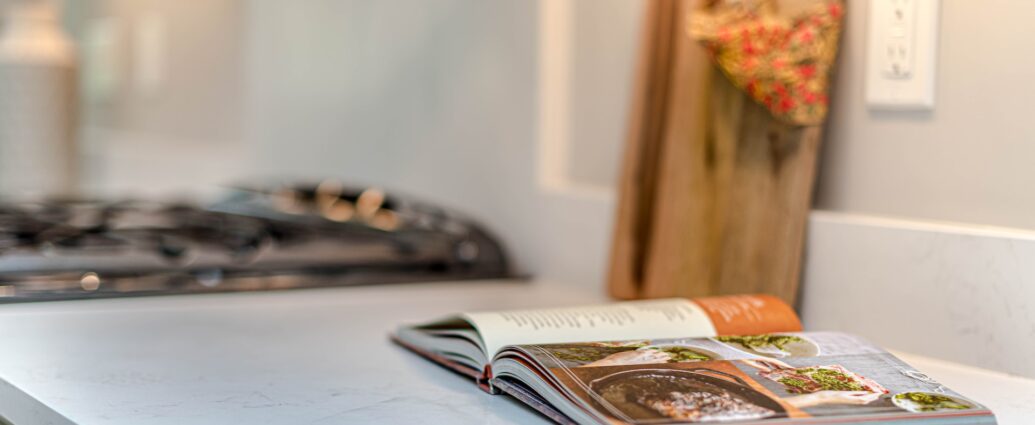 A cookbook lying on a kitchen counter.