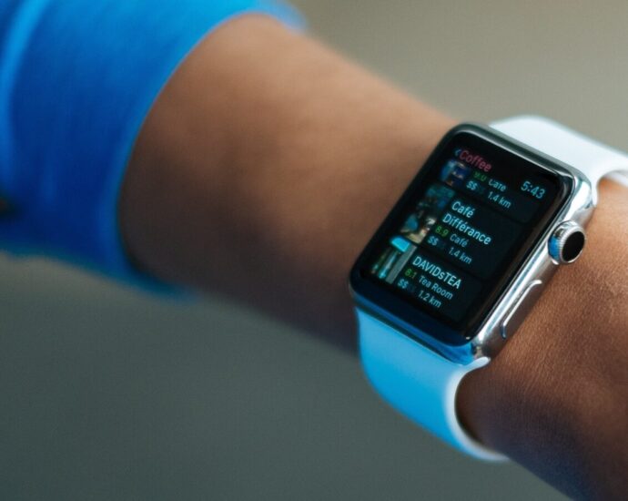 Image shows an outstretched arm sporting an Apple Watch, a device that is commonly used to track 10,000 steps