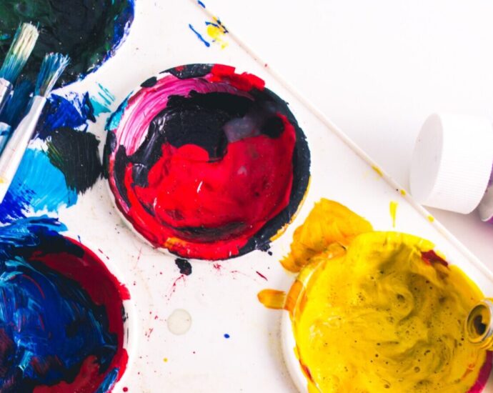 Image shows a painting palette filled with an assortment of paints. [hobbies]