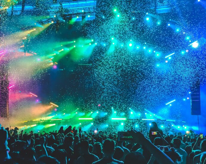 pink, green, and blue lights illuminating a concert stage.
