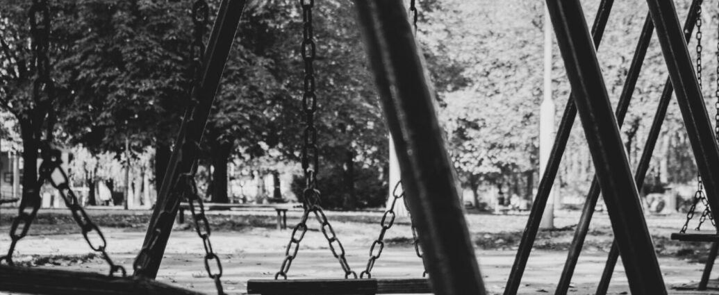 Empty swing set in black and white.