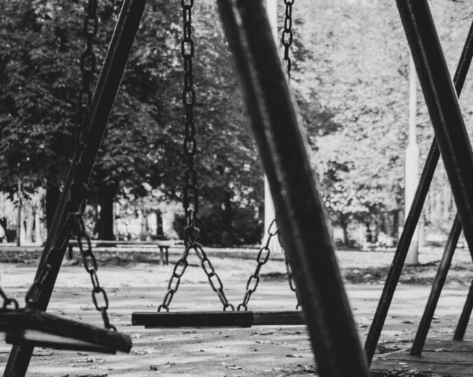 Empty swing set in black and white.