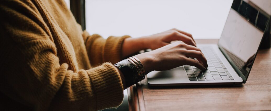 Pair of hands at a laptop keyboard upon a desk. Ghost-written.