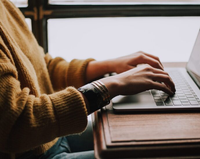 Pair of hands at a laptop keyboard upon a desk. Ghost-written.