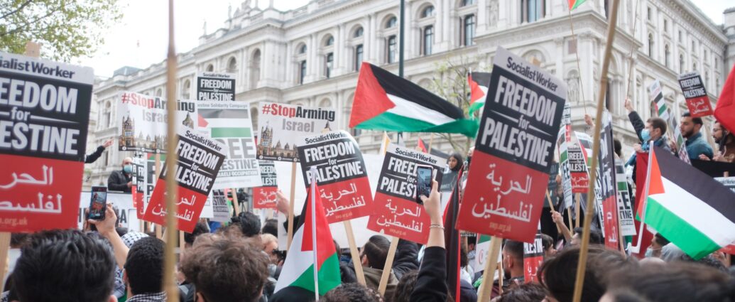 Israel-Palestine conflict. Citizens hold signs protesting the occupation of Palestine
