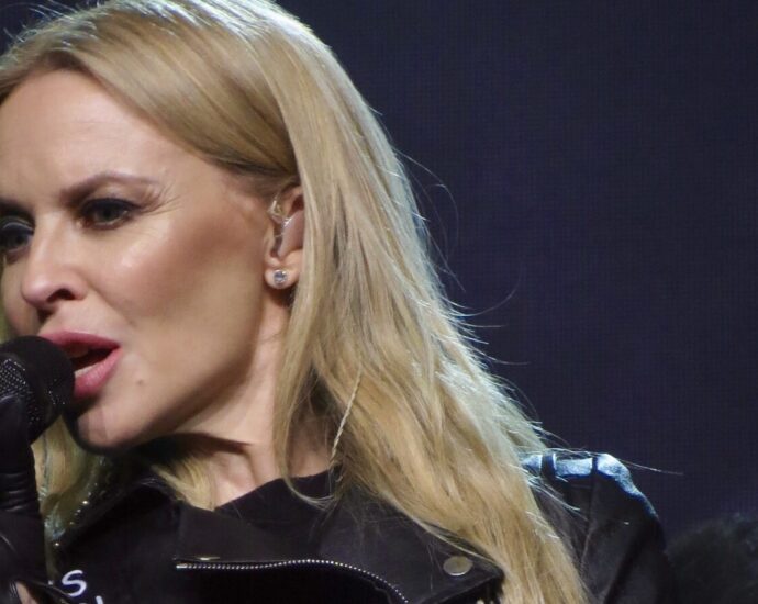 Blonde Kylie Minogue sings passionately into microphone