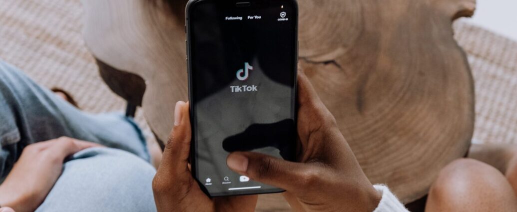 Someone holding a phone with TikTok open - TikTok is the hub of 'girlification'