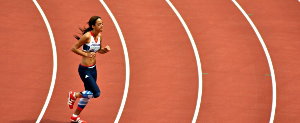 Image shows athlete Katarina Johnson-Thompson running across a track.