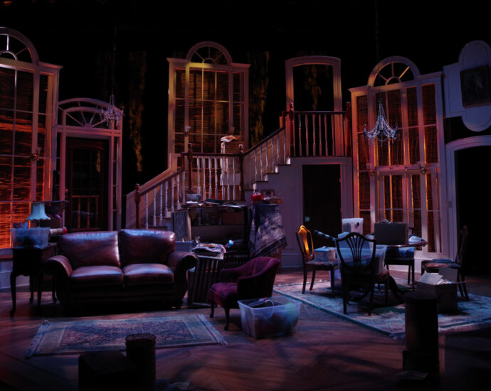 Living room set on stage with sofa, furniture and low lighting.