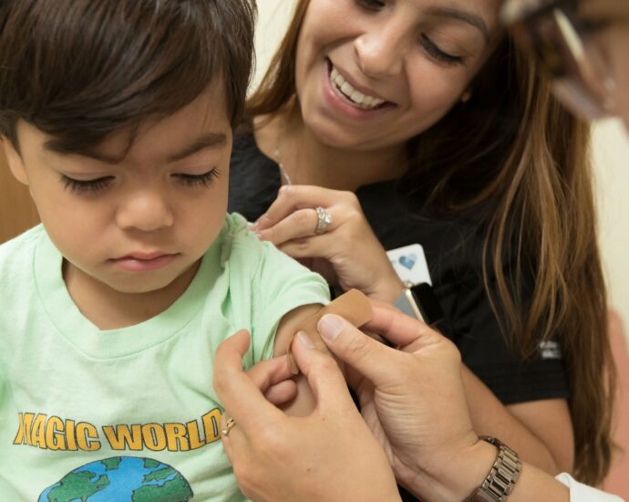 Image shows young boy receiving a vaccination in his arm.