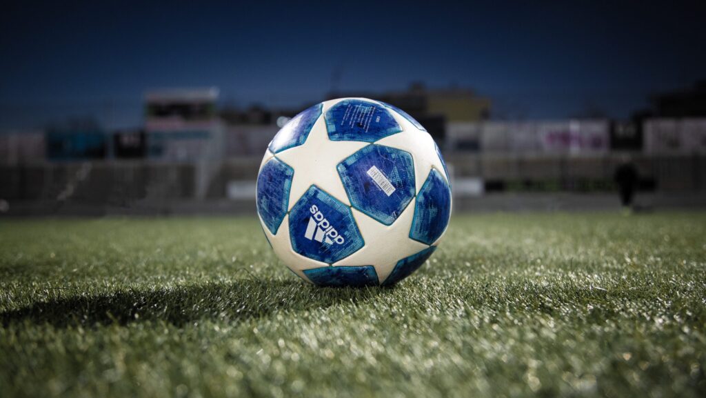 A blue and white football on a green pitch symbolising the Champions League