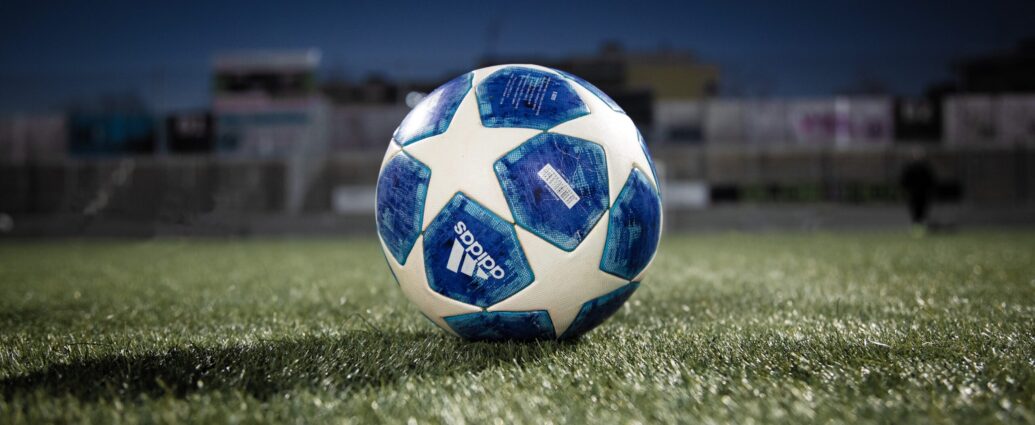 A blue and white football on a green pitch symbolising the Champions League