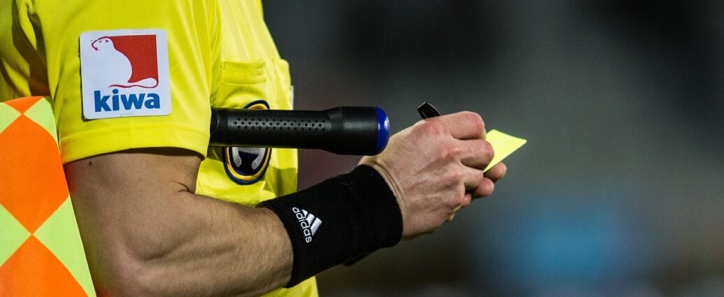 Referee issuing a yellow card in a football game