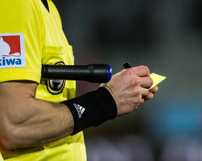 Referee issuing a yellow card in a football game