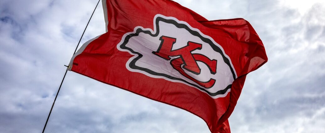 Kansas City Chiefs flag flying in front of building and cloudy sky