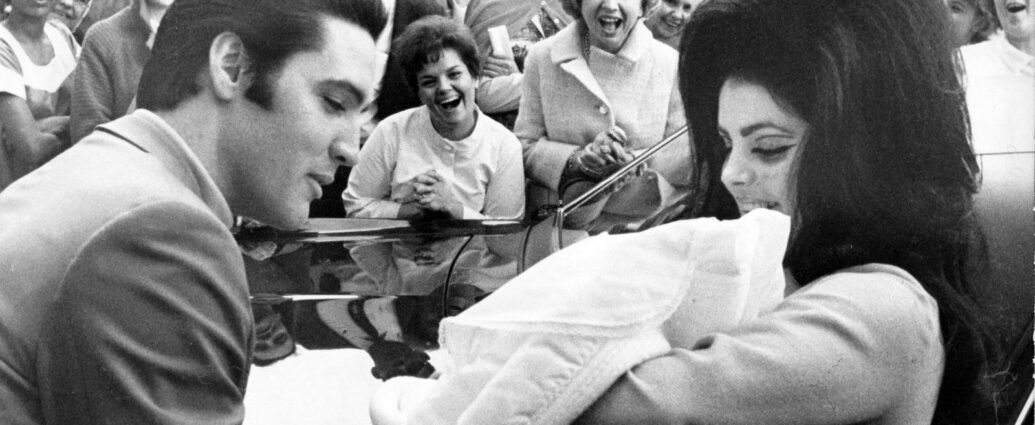 Black and white image of Elvis Presley and Priscilla with Lisa Marie, February 1968