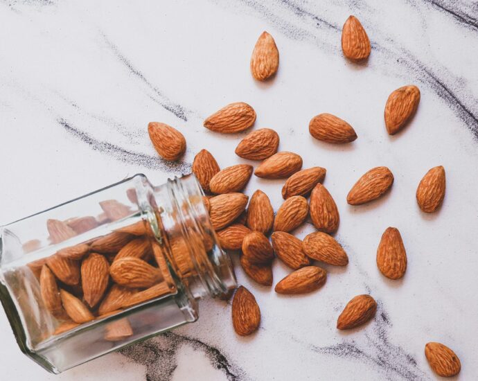 Brown almonds on white marble surface.