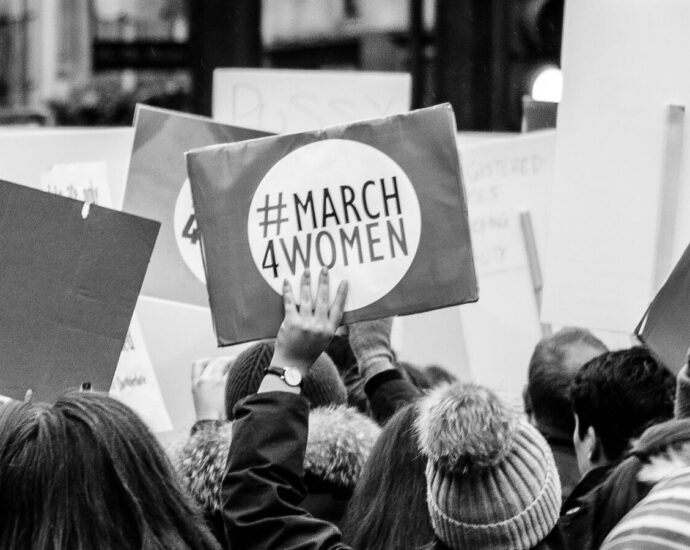 Image shows a protest placard that reads 'March 4 Women' [Women's History Month]
