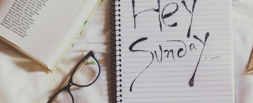 A notepad with writing saying 'Happy Sunday' next to a pair of glasses. Sunday Reset
