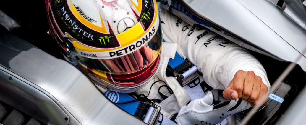 Image shows Lewis Hamilton in the driver's seat of his Mercedes F1 car.
