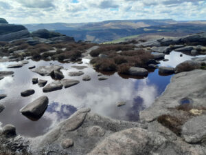 A hilly landscape in the background, a shallow body of water in the foreground.