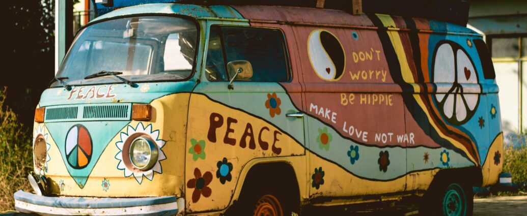 Blue and yellow Volkswagen hippie van with flowers and a peace symbol painted on