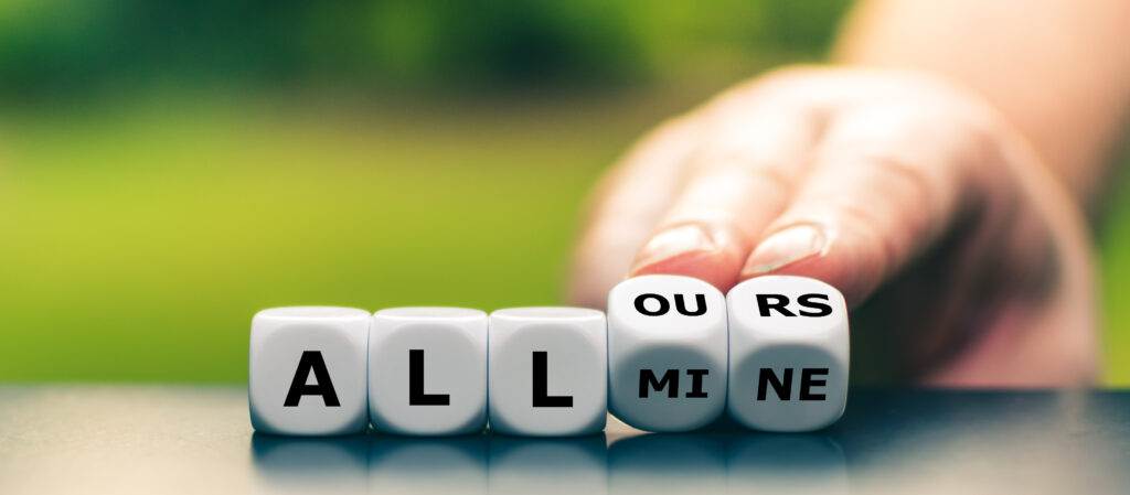A hand turns the last two dice in a row of five, changing the expression "all mine" to "all ours".