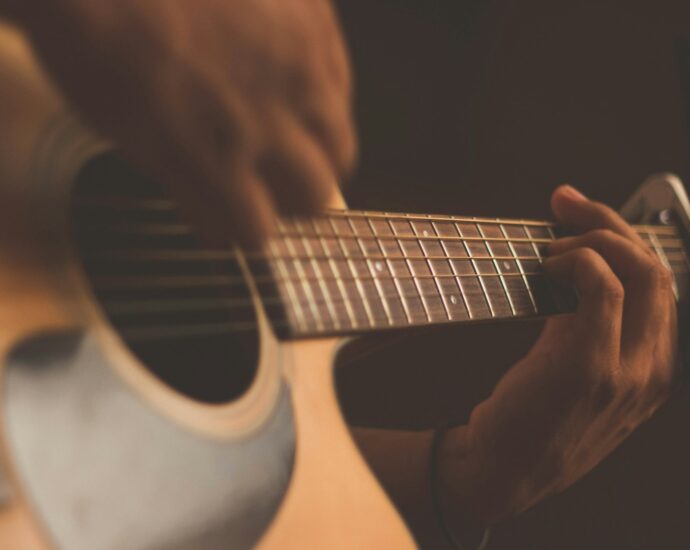 Individual playing the guitar. Representing A Complete Unknown